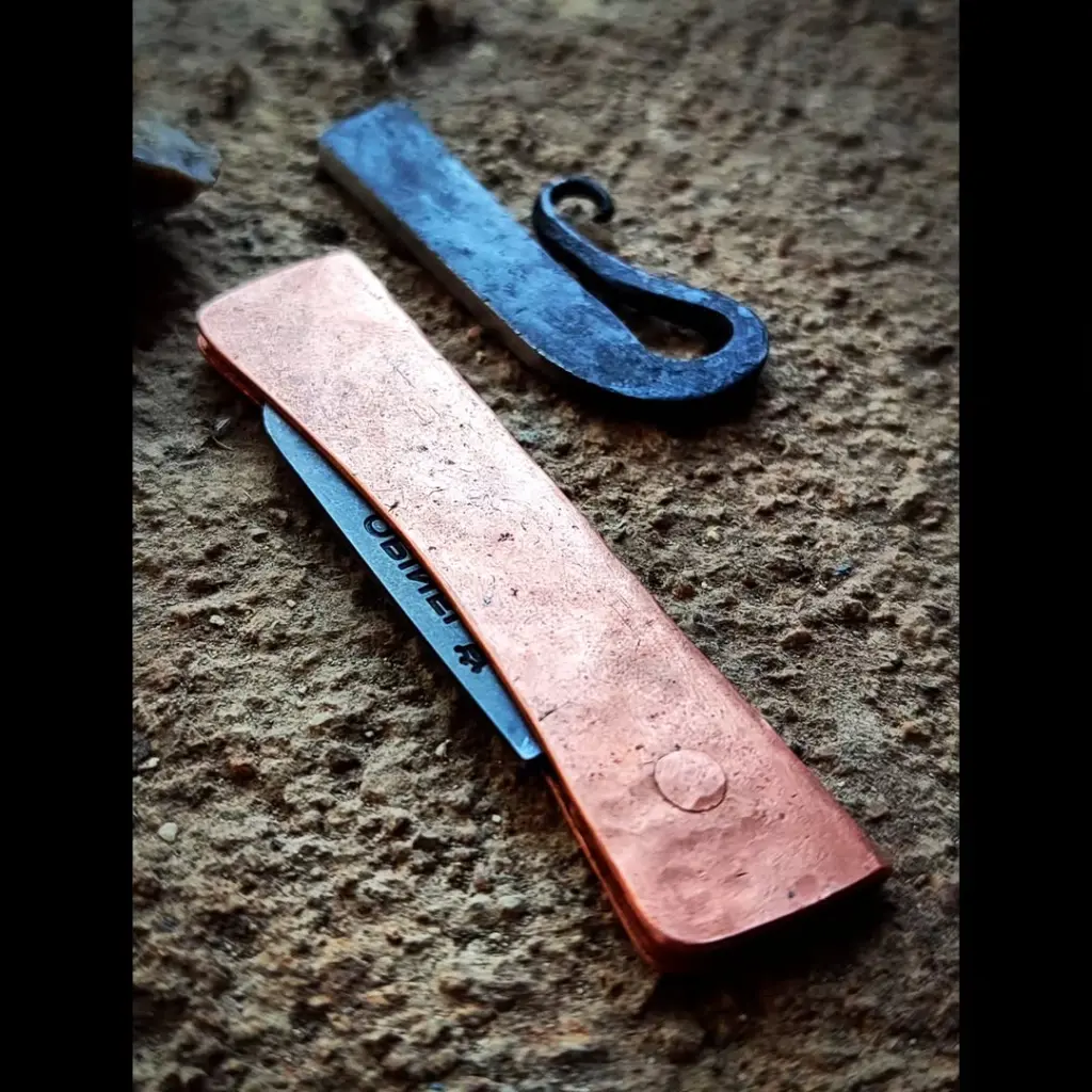 Pliant custom, lame d'Opinel modifiée, finition stonewash, manche en cuivre martelé, rivet cuivre.Grattoir à silex forgé et trempé, finition brute....#frictionfolder #coppersmith #flint #blacksmith #opinelmod #opinelcus-1.webp